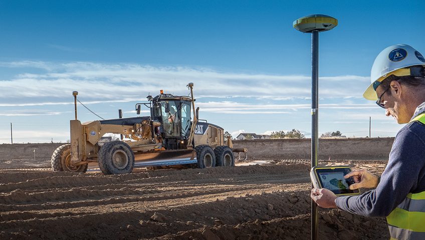 A CAT grader using Earthworks technology on a job site