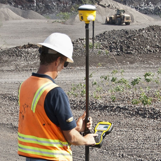 A construction worker using Trimble Technology on a job site