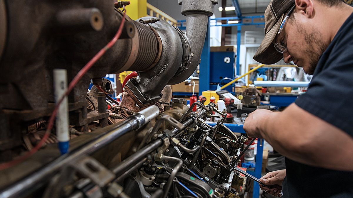 A technician servicing an engine